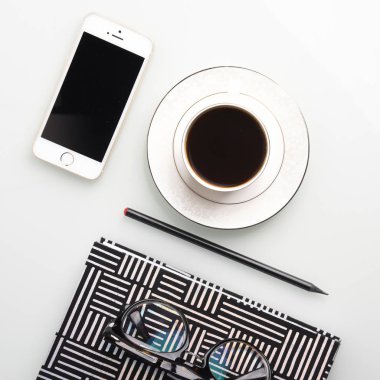Kahve fincanı, kalem, smartphone, gözlük ve çizgili Not defteri ile Ofis İşyeri