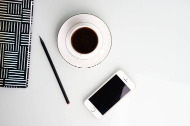 Çalışma alanı kahve fincanı, kalem, smartphone ve çizgili Not defteri ile