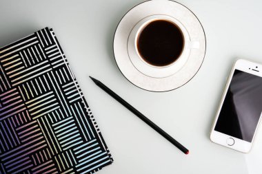 Çalışma alanı kahve fincanı, kalem, smartphone ve çizgili Not defteri ile