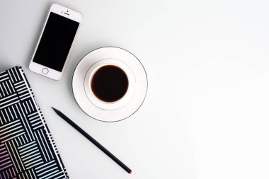 Çalışma alanı kahve fincanı, kalem, smartphone ve çizgili Not defteri ile