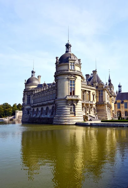 Chantilly, Fransa - 21 Ağustos 2018: Chantilly kale yansıma pürüzsüz nehir ile görünümünü.