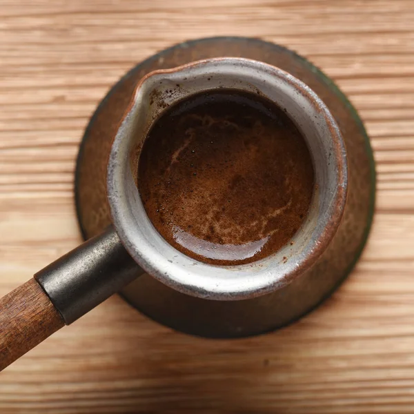 コピー スペースを持つ木製の背景に銅のトルコ コーヒー ポットの上から見る — ストック写真