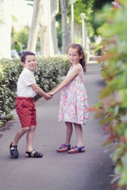 Parkta el ele yürüyen çocukların arka görünümü