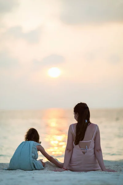 母亲和她的小女儿在海滩上日落 — 图库照片
