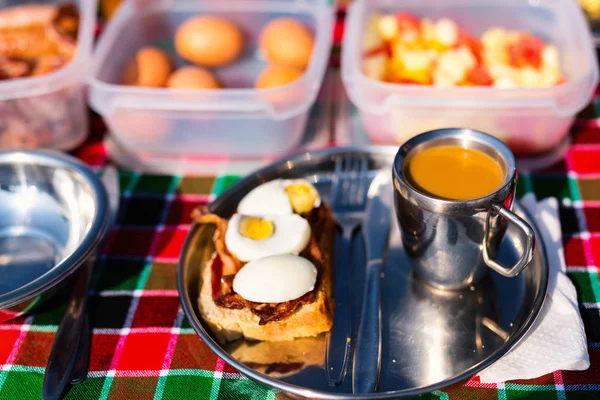 Luxury safari picnic bush breakfast with eggs, bacon and coffee
