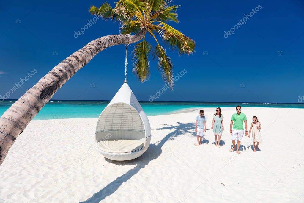 Beautiful family with kids on a tropical beach during summer vacation