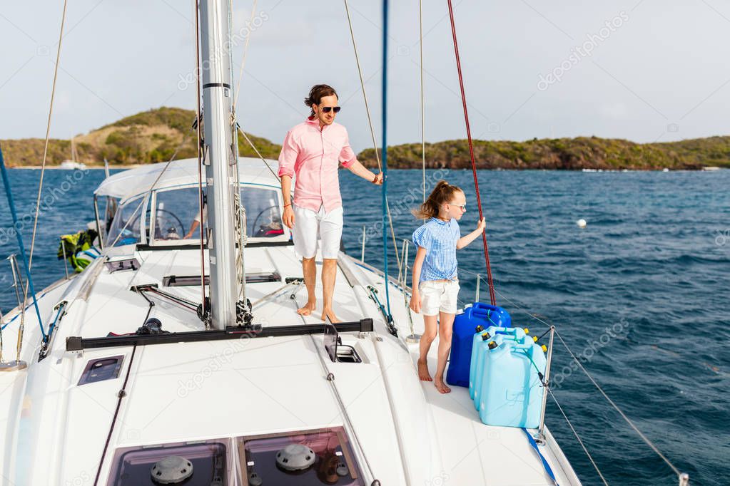 Father and daughter on board of sailing yacht having summer travel adventure