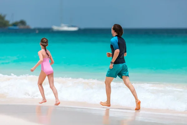 父亲和他可爱的女儿在海滩上奔跑 — 图库照片