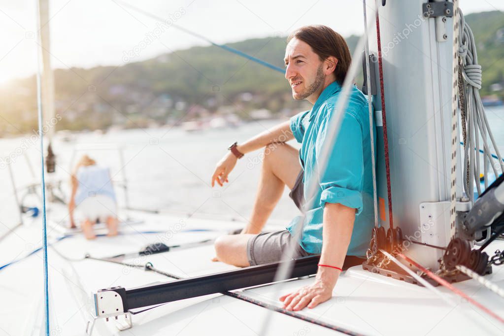 Family of father and daughter on board of sailing yacht enjoying sunset