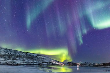 Incredible Northern lights Aurora Borealis activity above the coast in Norway clipart