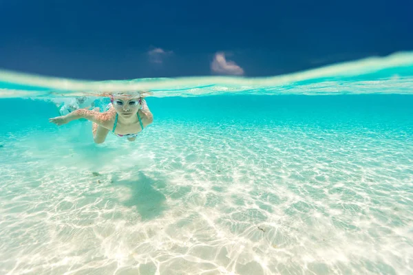 在热带海洋中游泳的小女孩拆分水下照片 — 图库照片