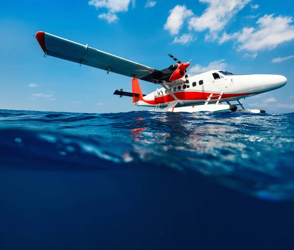 Split underwater photo of small seaplane on water