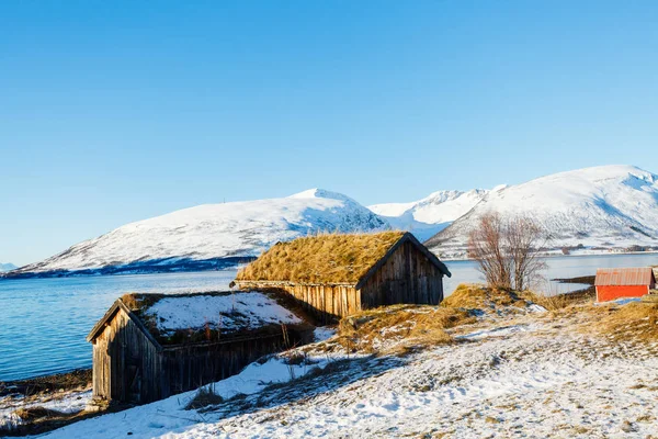 息をのむフィヨルドの風景を望む木の小屋と北ノルウェーの美しい冬の風景 — ストック写真