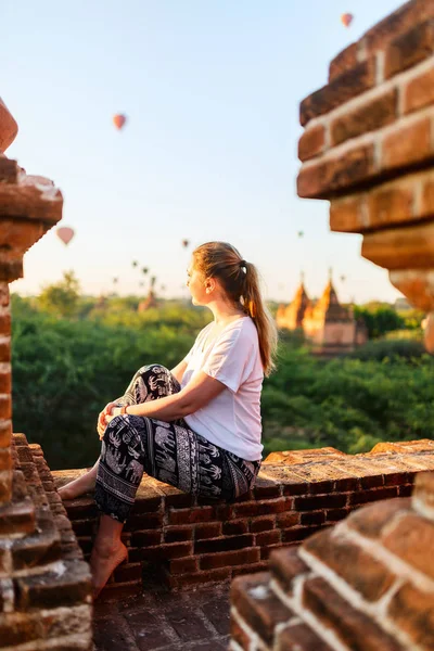 熱い空気バルーンが上空何千もの古代の塔バガン ミャンマーで日の出の屋上の景色を楽しみながら美しい女性 — ストック写真