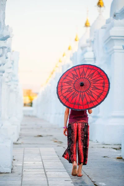 マンダレー ミャンマーで美しい白 Kuthodaw 塔で伝統的なビルマの傘を持つ少女の背面図 — ストック写真