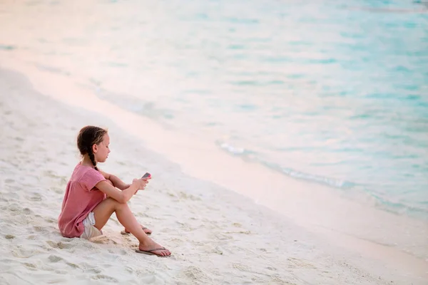 Kind Spielt Bei Sonnenuntergang Tropischen Strand Auf Einem Tragbaren Spielgerät — Stockfoto