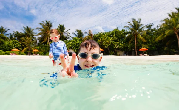 在暑假期间 可爱的小女孩和可爱的男孩在热带海水中飞溅 — 图库照片