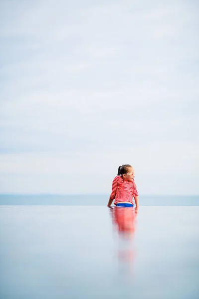 愛らしい女の子で無限のスイミングプールで海のリゾート — ストック写真