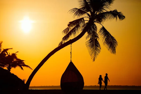 夕暮れ時に熱帯のビーチでロマンチックなカップルのシルエット — ストック写真