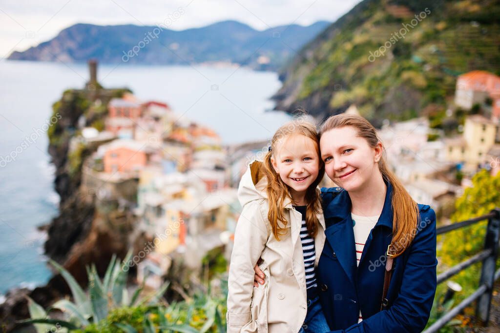 Mother and daughter enjoying scenic view of colorful Vernazza village in Cinque Terre Italy