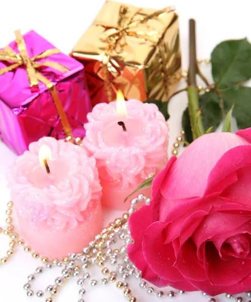 pink rose, pink candles and a box with a gift