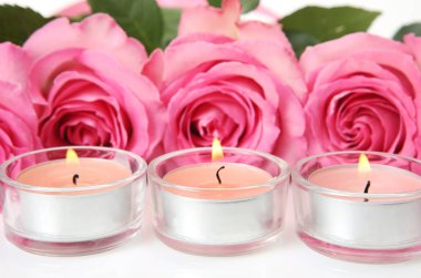 buket pembe gül ve yanan mumlar