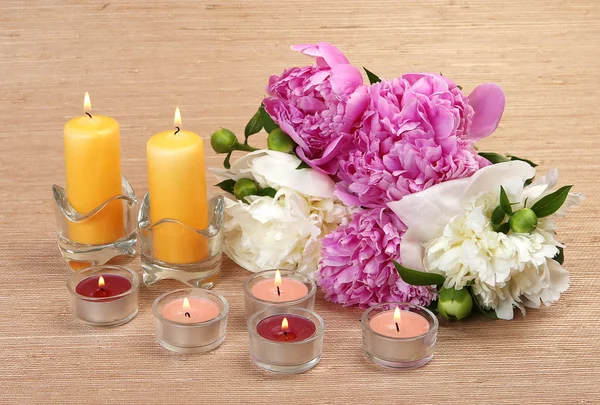 粉红色和白色的牡丹花束和燃烧的蜡烛 — 图库照片