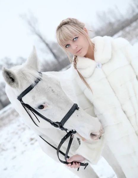 Girl in a white coat and with a white horse — Stock Photo, Image