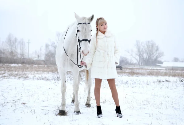 Girl in a white coat and with a white horse — Stock Photo, Image