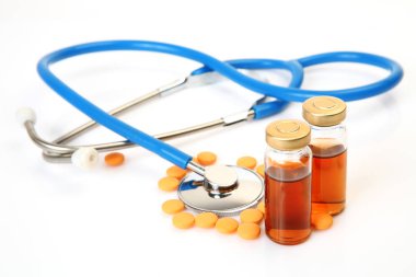 beyaz arka plan üzerinde ilaç şişeleri ve stetoskop