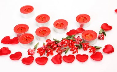 kırmızı çiçekler, kalpler ve beyaz arka plan üzerinde kırmızı yanan mumlar