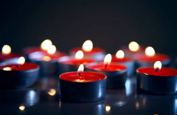 Rode brandende kaarsen in het donker — Stockfoto