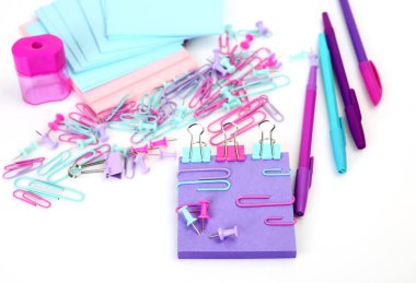 Beyaz arka planda izole renkli dağınık ofis malzemeleri çeşitliliği