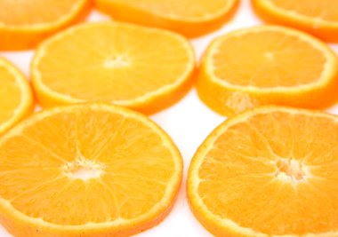 Beyaz arka planda izole Yüzüklerin içine dilimlenmiş olgun portakallar