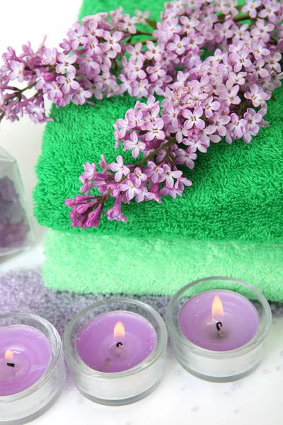 Cotton towels, lilac and candles — Stock Photo, Image