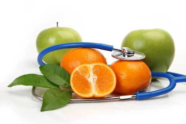 Fruits mûrs sur fond blanc et stéthoscope — Photo