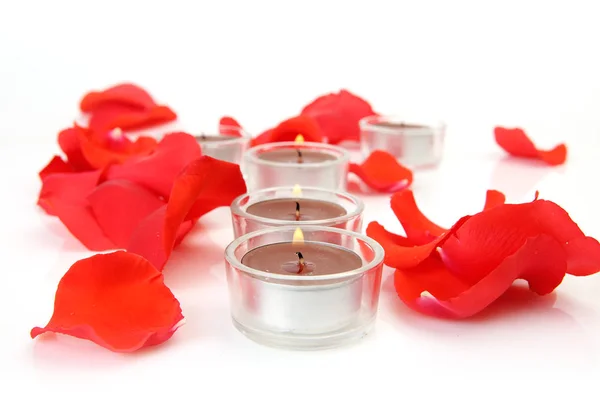 Scharlachrote Rosenblätter Und Brennende Kerzen Für Romantische Stimmung — Stockfoto