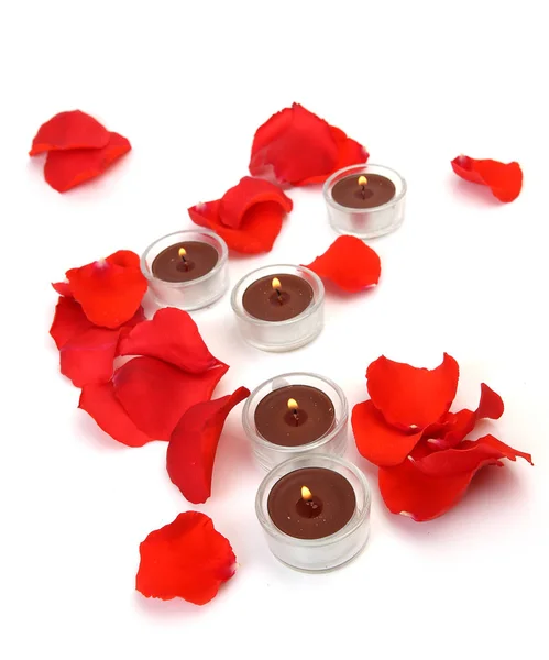 scarlet rose petals and burning candles for romantic mood