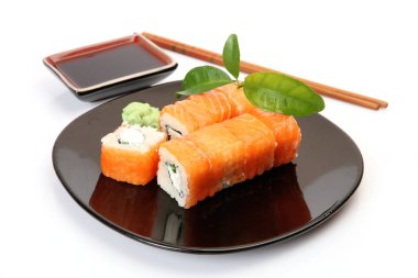 siyah bir tabak üzerinde pirinç ve balık ile rulo