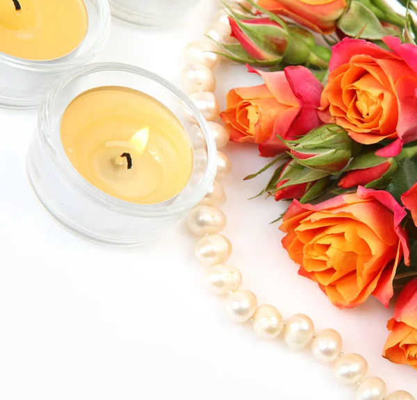 Gyöngy nyaklánc, szép rózsa és égő gyertyákat — Stock Fotó