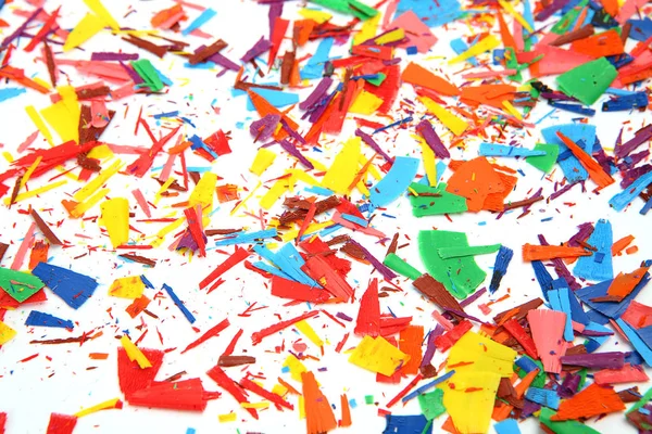 Aparas de lápis de cera coloridos em um fundo branco — Fotografia de Stock