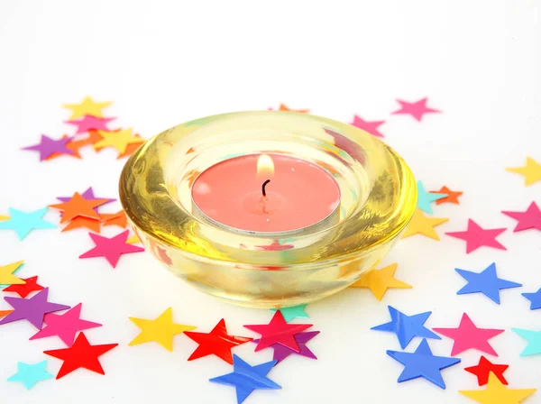 Star confetti and burning candle — Stock Photo, Image