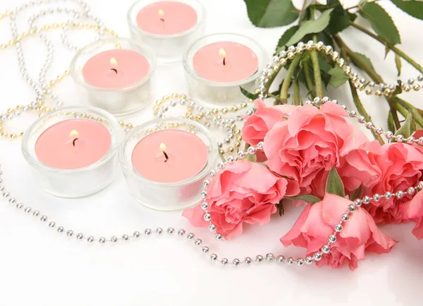 Bouquet of beautiful fragrant roses and pink candles — Stock Photo, Image