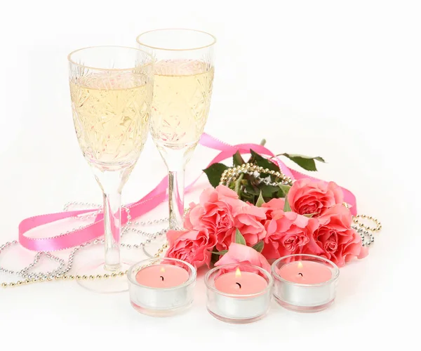 Σαμπάνια σε ένα ποτήρι, ροζ τριαντάφυλλα και καίγοντας κεριά — Φωτογραφία Αρχείου