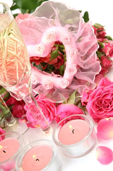 Σαμπάνια σε ένα ποτήρι, ροζ τριαντάφυλλα και καίγοντας κεριά — Φωτογραφία Αρχείου