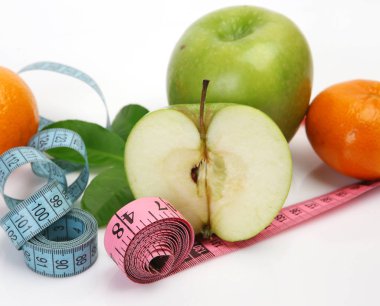 Beyaz arka planda yeşil elma ve mezura.