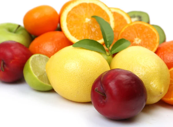 Naranjas, ciruelas y otras frutas sobre un fondo blanco — Foto de Stock