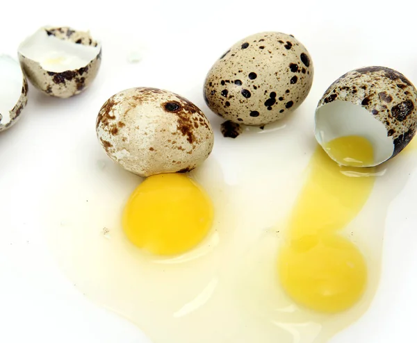 Broken quail eggs on a white background — Stock Photo, Image