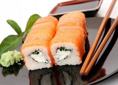 siyah bir tabak üzerinde pirinç ve balık ile rulo