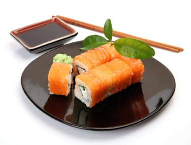 siyah bir tabak üzerinde pirinç ve balık ile rulo